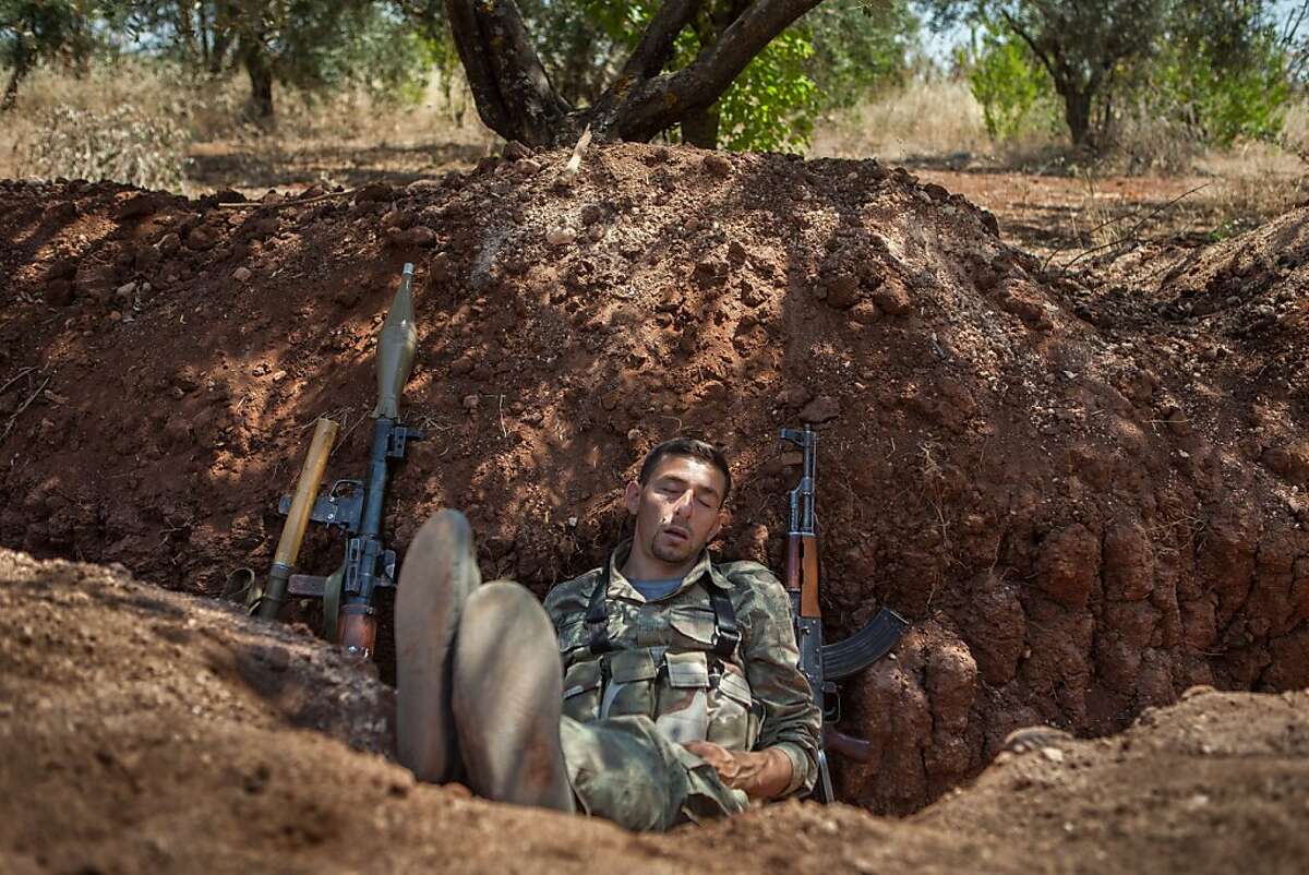 TOPSHOTS A rebel fighter Sukhur Alsham has a break sleeping after his night shift in a trench along the highway that connects Idlib city with Latakia, 100m far from the regime's forces's positions, on July 15, 2013. According to the Syrian Observatory for Human Rights watchdog, more than 100,000 people have been killed since the uprising began in March 2011, more than 5,000 of them children under the age of 16. AFP PHOTO DANIEL LEAL OLIVASDANIEL LEAL OLIVAS/AFP/Getty Images