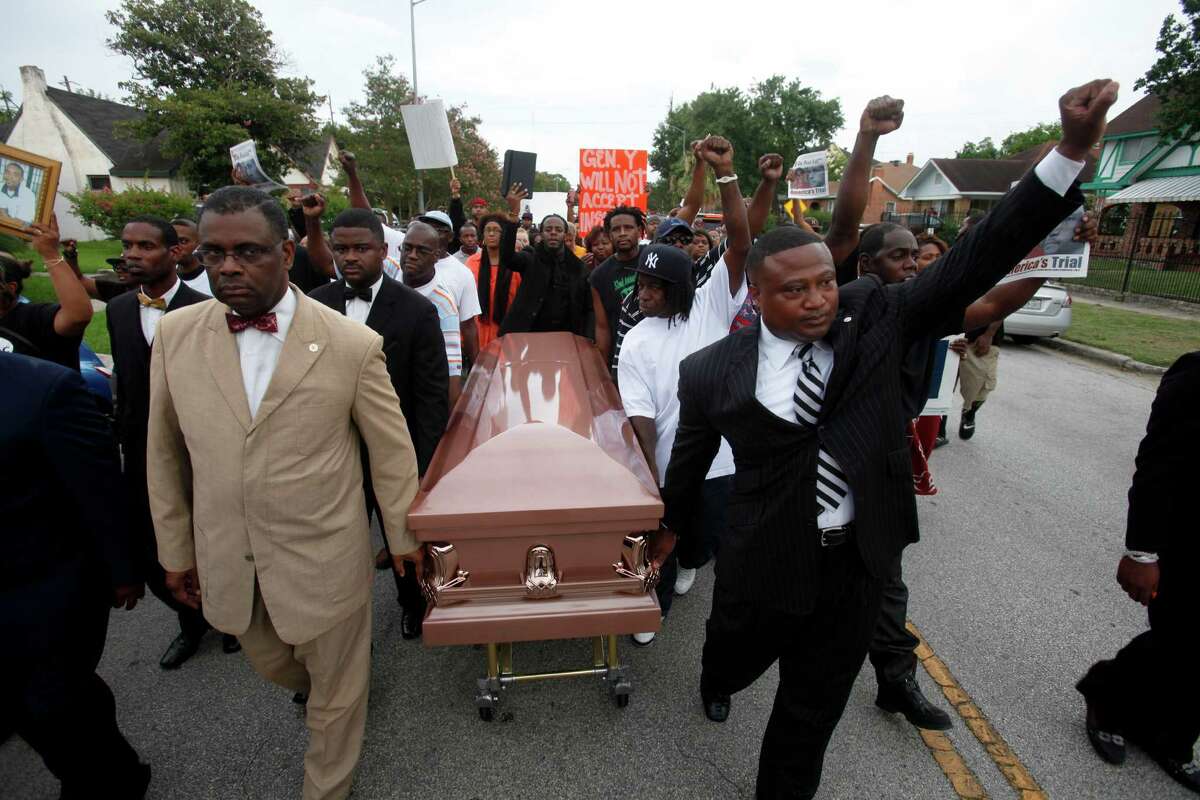 Protesters stop traffic on Texas 288 Monday, above, as activist Quanell X, at right, and local community leaders and hip-hop stars lead a protest that began at the Byrd Funeral Home on Wheeler.