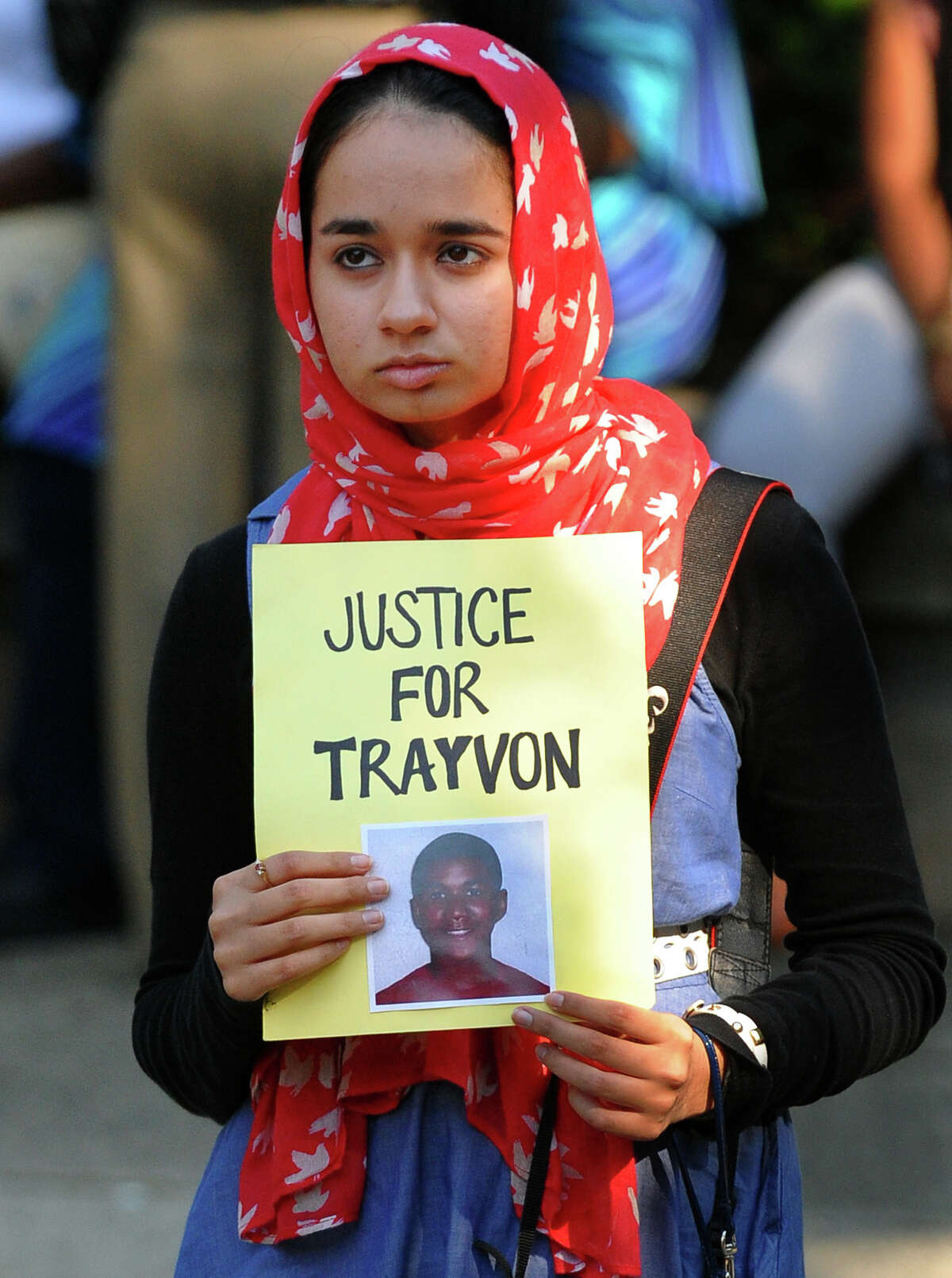 Amina Seyal, of Fairfield, holds up a sign while attending a demonstration protesting the acquital of George Zimmerman, in front of the U.S. District Courthouse in downtown Bridgeport, Conn. on Tuesday July 16, 2013.