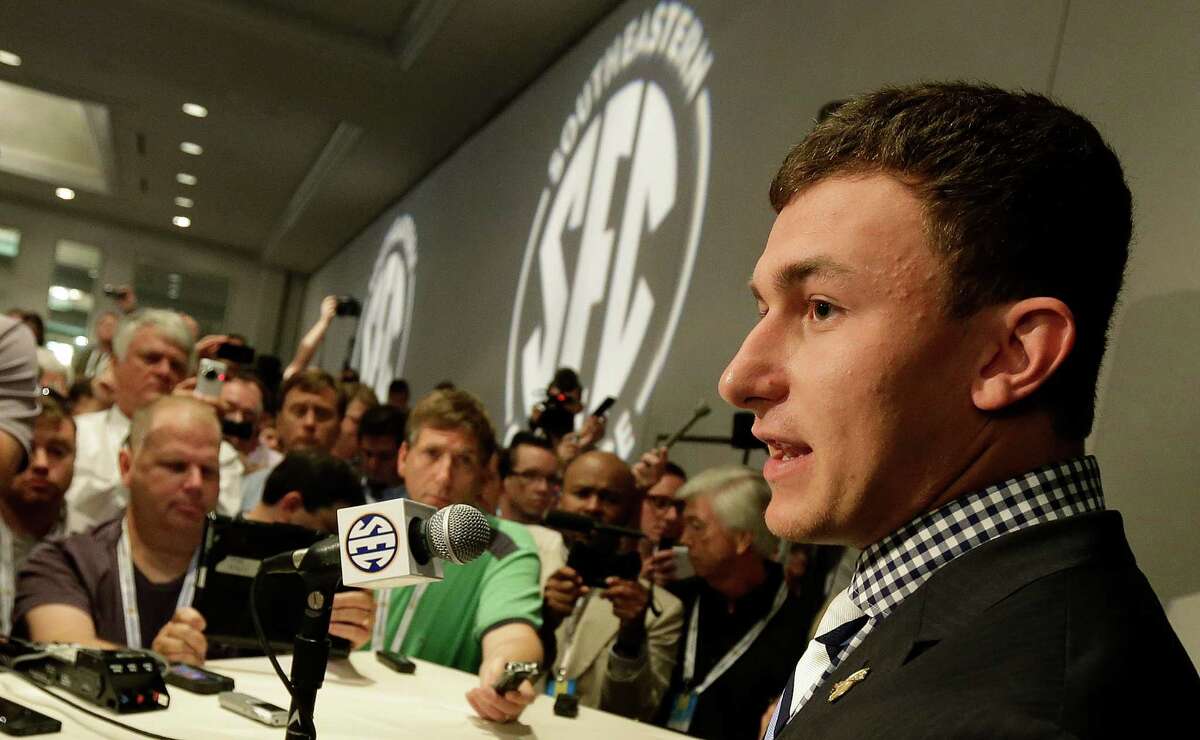 Texas A&M quarterback Johnny Manziel talks with reporters during the Southeastern Conference football Media Days in Hoover, Ala., Wednesday, July 17, 2013. (AP Photo/Dave Martin)