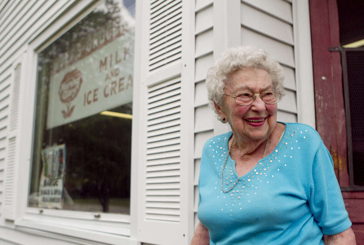 Margaretta Wolf, 96, stands in front of the grocery store she's owned for 54 years. She thwarted a robbery attempt by telling the knife-wielding man she would not open the cash register.