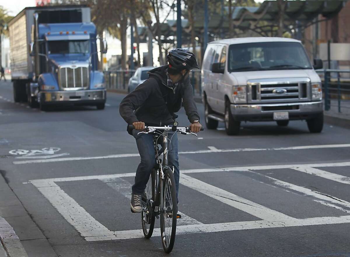 A bicyclist keeps an eye on traffic as he merges with vehicles at the end of a bike lane on King Street between 2nd and 3rd streets in San Francisco, Calif. on Tuesday, Feb. 12, 2013. A woman riding her bicycle was struck and killed after she collided with a cement truck last weekend.