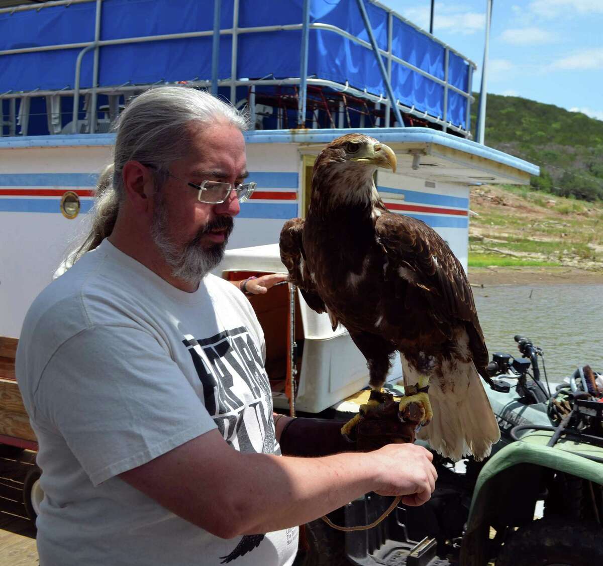 Ian Joplin of Last Chance Forever Bird of Prey Conservancy holds a bald eagle on the Vanishing Texas River Cruise dock.