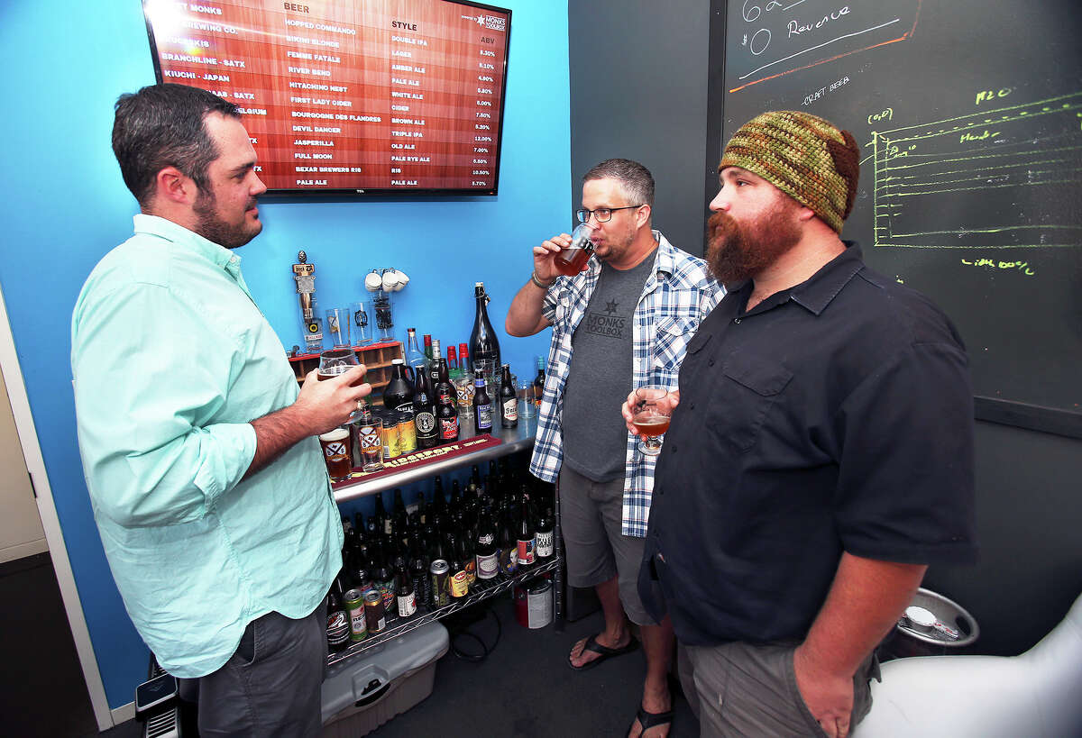 Zac Harris (from left) , Jeremy Karney and Les Locke discuss marketing of their brew during a happy hour at Monk's Toolbox on July 5, 2013.