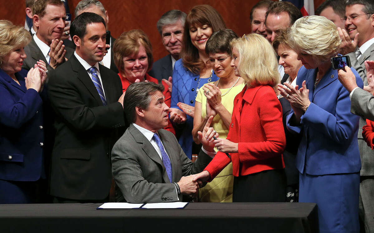 Governor Rick Perry congratulates Representative Jodie Laubenberg R-Parker after he signs into law the abortions restrictions bill on July 18, 2013.