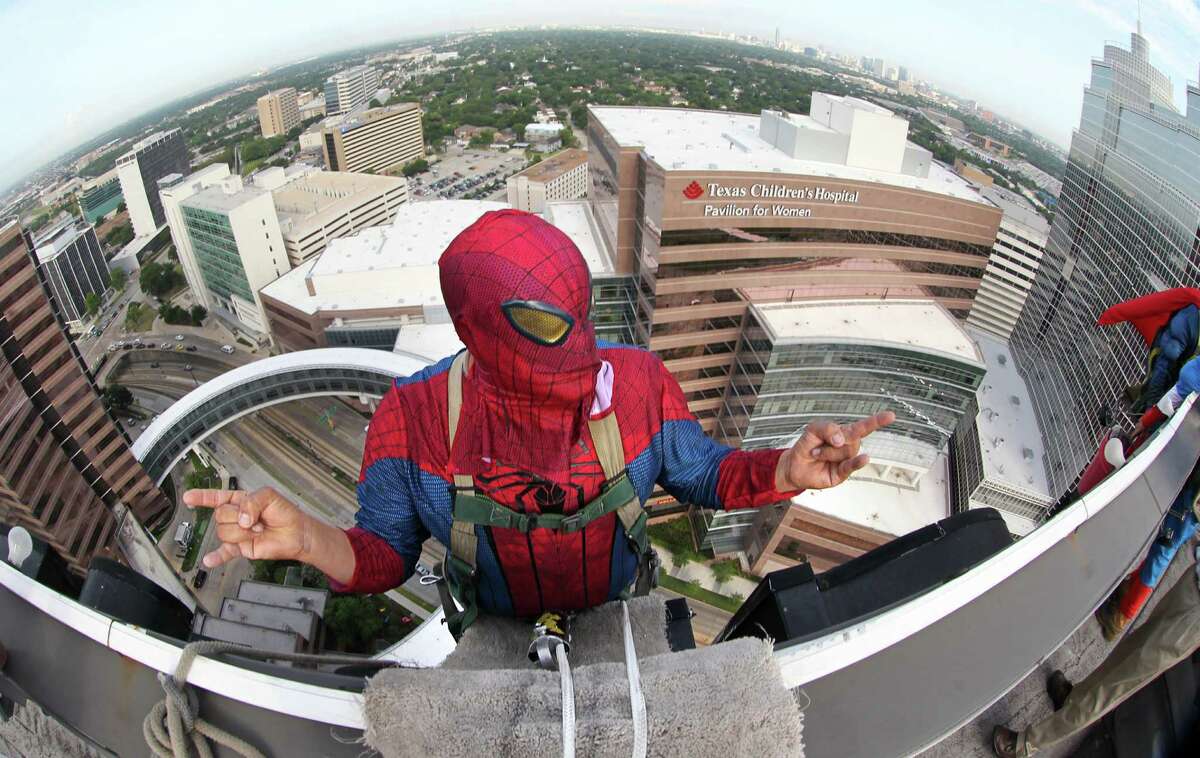Gerber Abarca as "Spiderman" rehearses his poses while dangling off the building to begin scaling the hospital exteriors to wash windows and surprise patients at Texas Children's Hospital on Friday, July 19, 2013, in Houston.