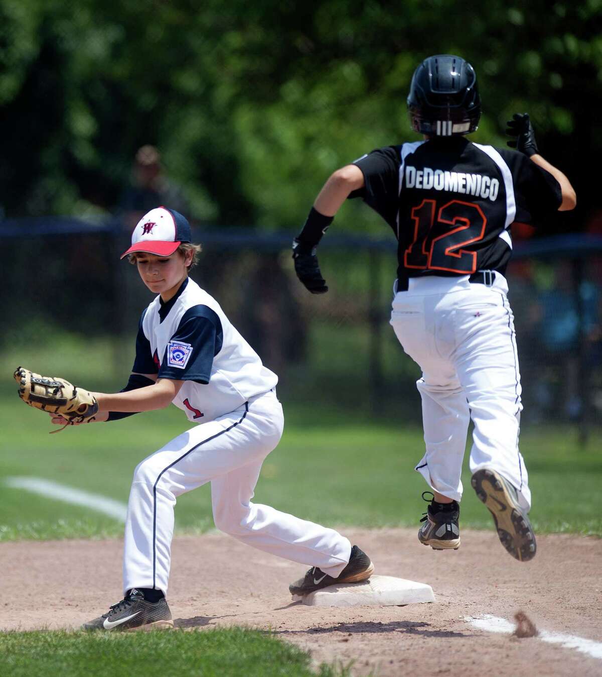 Orange's Drew DeDomenico is out at first as Westport baseman Chris Drbal catches the ball during Saturday's Little League Section 1 tournament game at Frank Noto Field in West Beach Park in Stamford, Conn., on July 20, 2013.