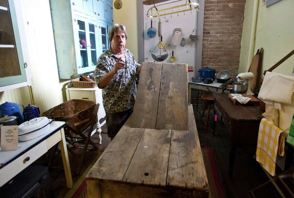 Scott Hanson, owner of the Antique Warehouse, shows a birthing table that was used when the building was the Oleander Hotel in Galveston's red-light district.