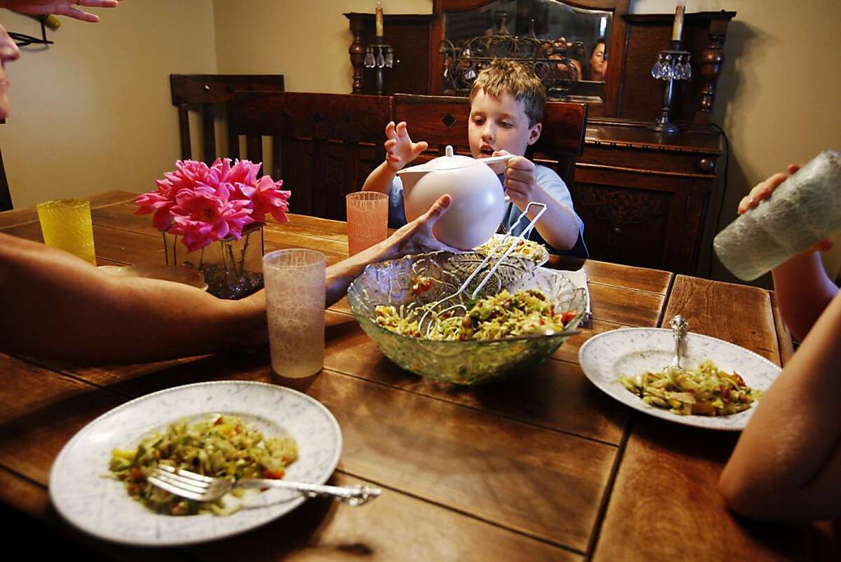Keenan Fitzgerald, 8, pours himself some water with the help of his mother during supper on Wednesday, July 17, 2013 in Concord, Calif.