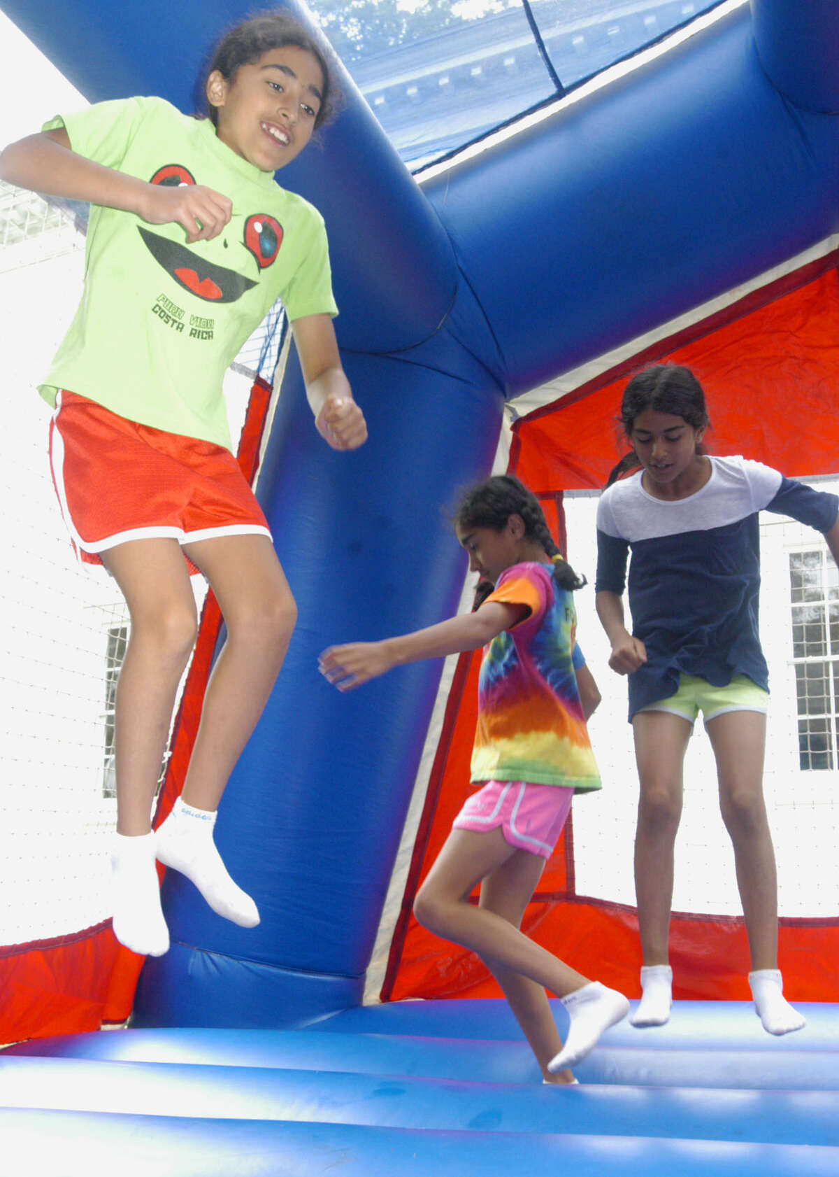 Kayla Dhalla, left, and her sisters, Rhea, center, and Alyssa frolic during the Washington Congregational Church's annual Green Fair, July 13, 2013.