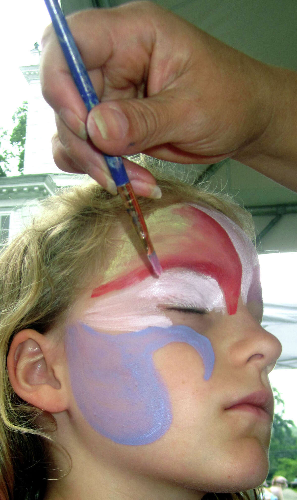 Katie Bratone, 8, of Pelham, N.Y. is a patient model for the face-painting talents of Marisabel Artieda during the Washington Congregational Church's annual Green Fair, July 13, 2013.