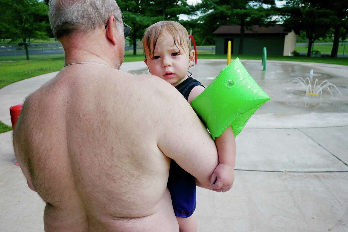 Harold Beyer of Bethlehem carries his grandson, Nicholas Beyer, 1, from Rotterdam, to a children's water play area at the Elm Avenue Pool on Tuesday afternoon, July 23, 2013, in Bethlehem, N.Y. (Paul Buckowski / Times Union)