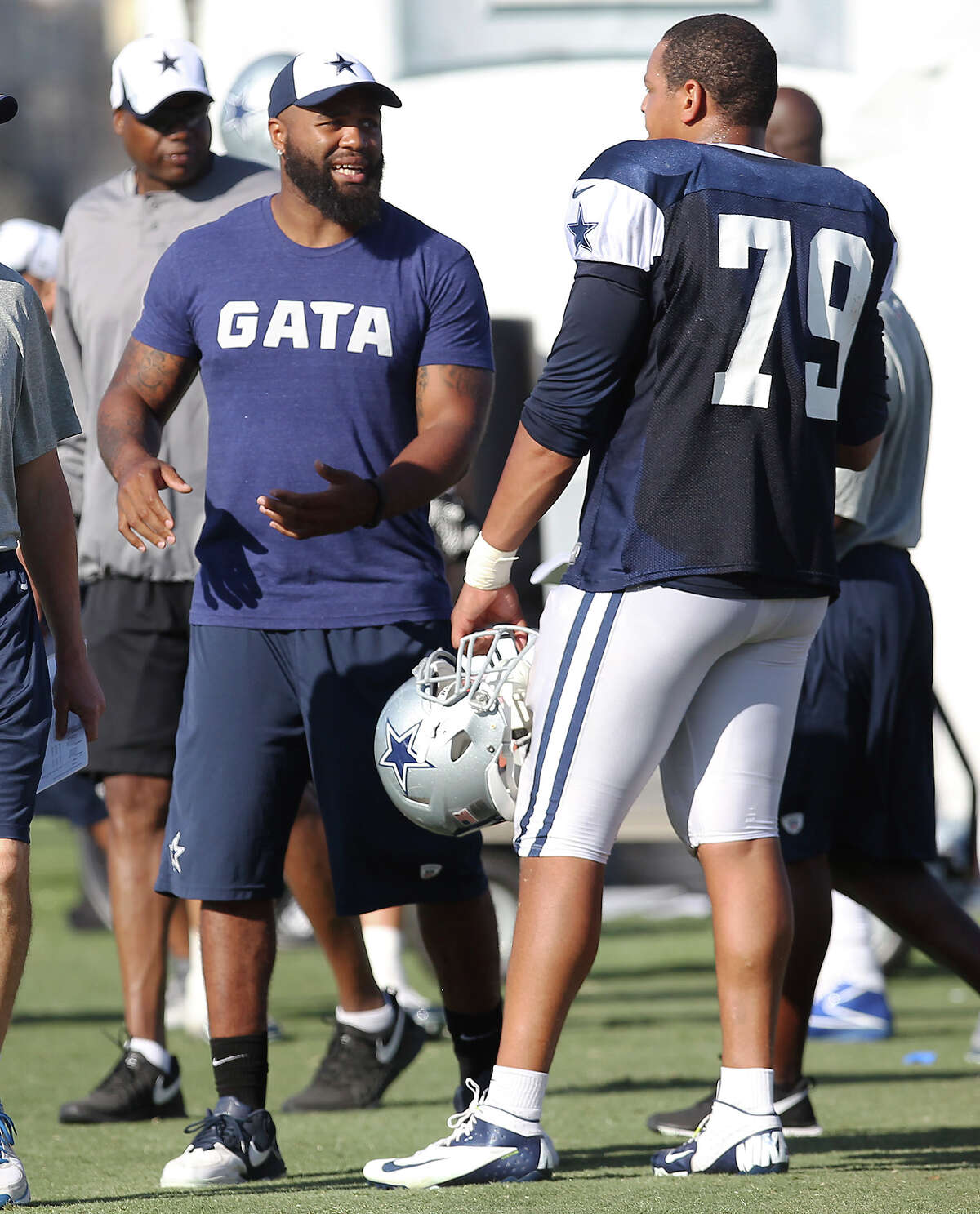 Injured defensive end Anthony Spencer (center) offers help to fellow player Ben Bass (79) during the afternoon session of the 2013 Dallas Cowboys training camp on Tuesday, July 23, 2013 in Oxnard.