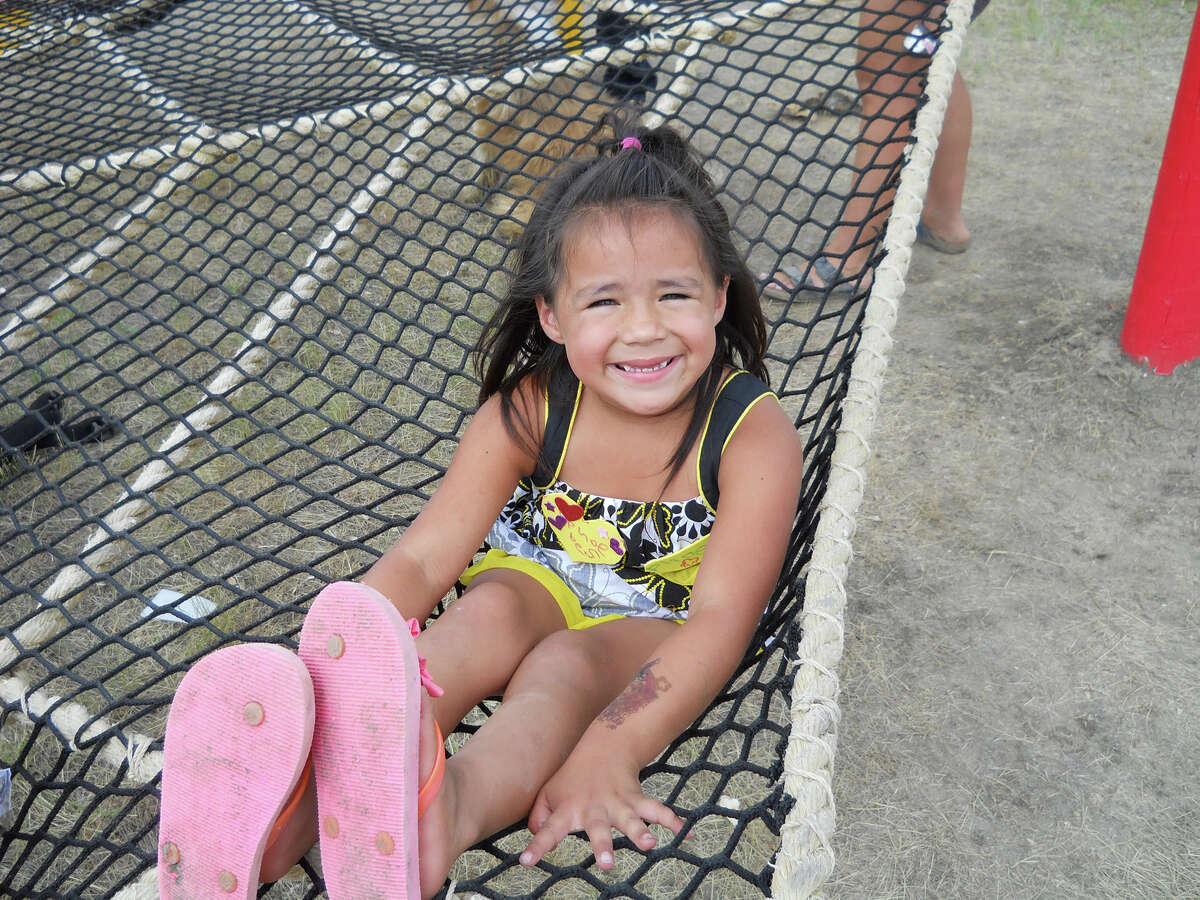 A young Lakota Sioux girl relaxes in the "spider web," a trampoline-like structure that's a favorite with Indian kids at Simply Smiles in La Plant, S.D.