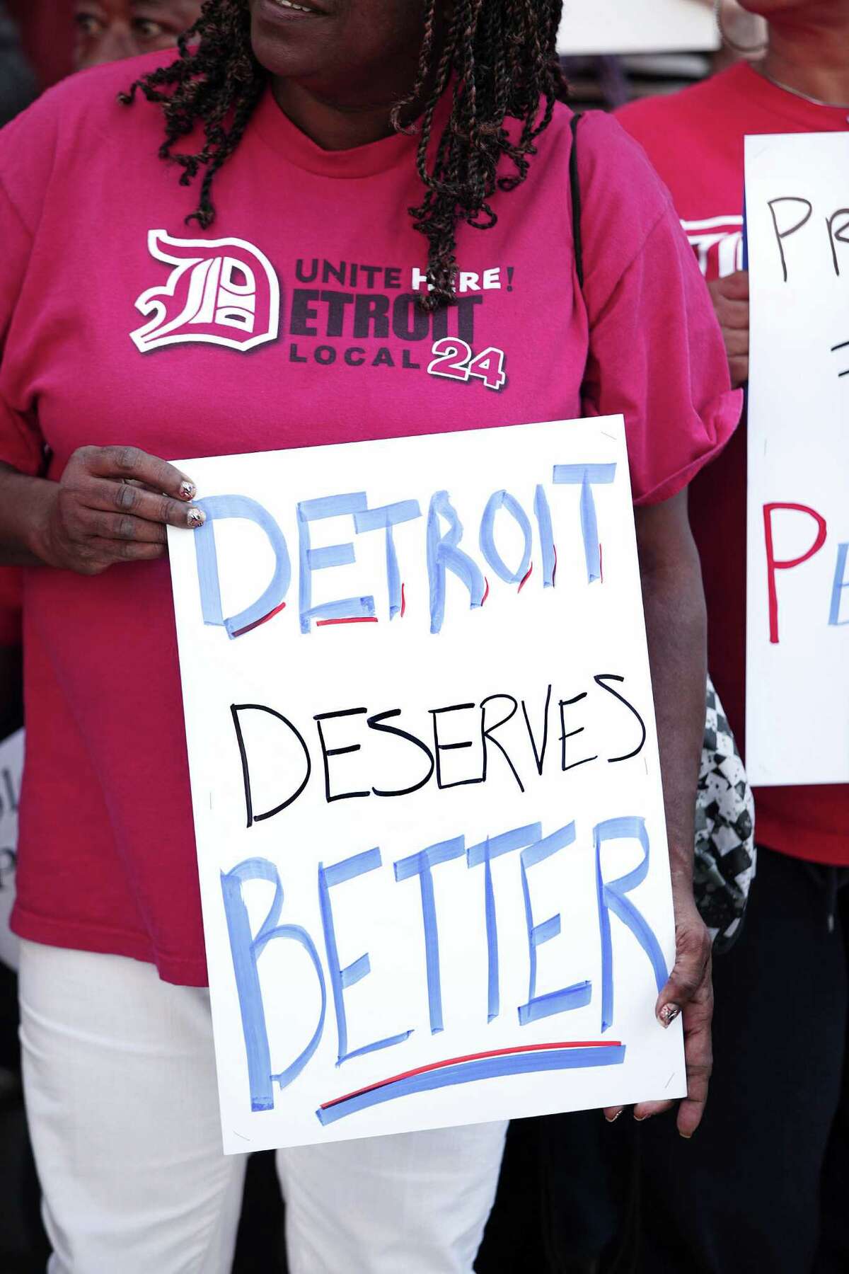 A woman protests Wednesday outside the U.S. Courthouse in Detroit during the city's bankruptcy hearing. Detroit owes approximately 100,000 creditors.