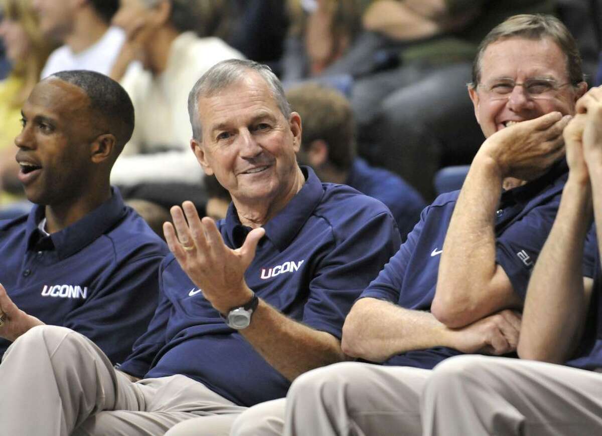 Connecticut's men's basketball head coach Jim Calhoun, center, gestures as he watches the slam dunk competition with assistant coaches Patrick Sellers, left, and George Blaney, right, at the First Night NCAA basketball exhibition, in Storrs, Conn., Friday, Oct. 16, 2009. (AP Photo/Jessica Hill)