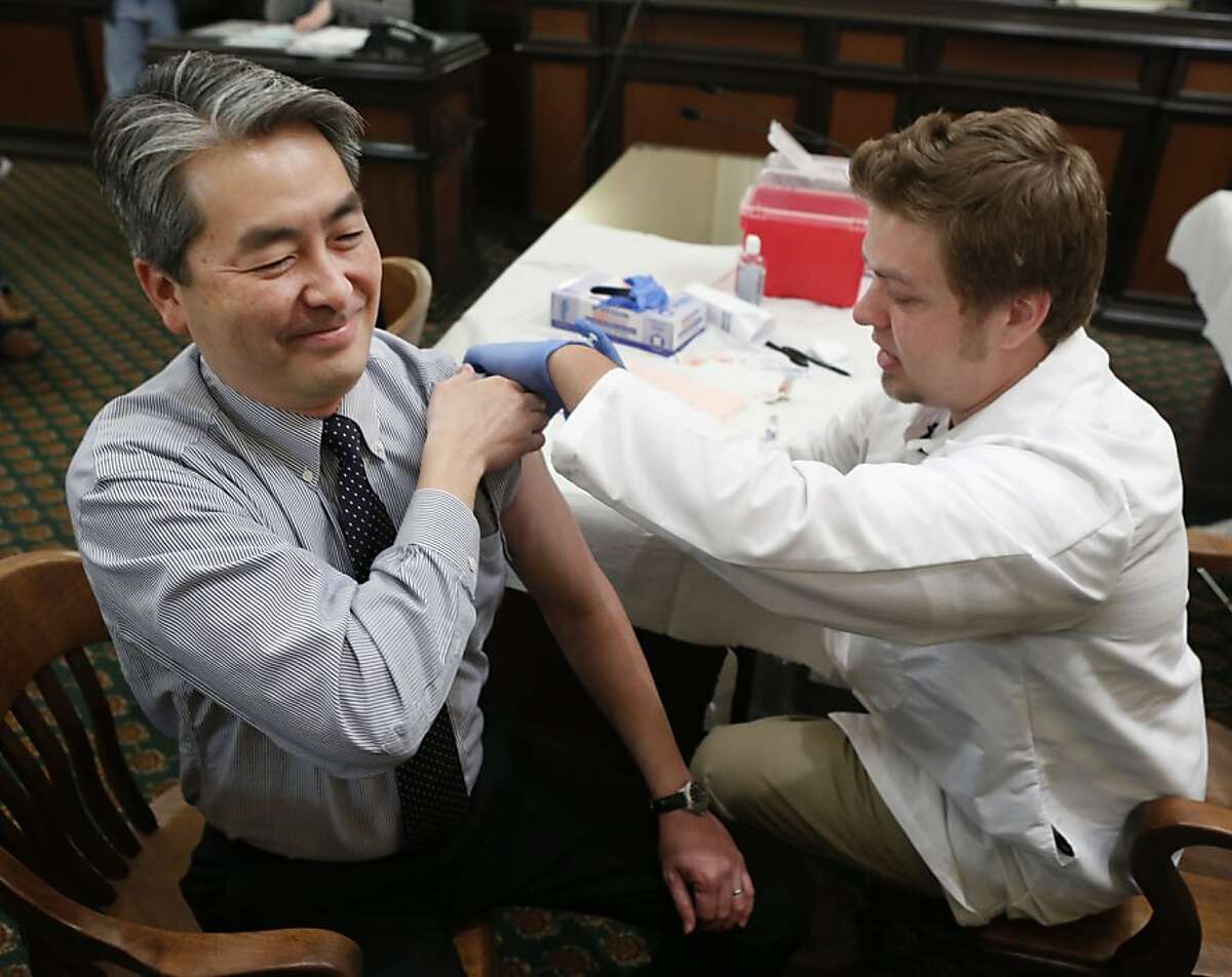 FILE - In this Monday, Jan. 28 , 2013 file photo, Assemblyman Al Muratsuchi, D-Torrance, reacts as he receives a flu shot from Tyler Poncy, a licensed vocational nurse during a free flu vaccine clinic at the Capitol in Sacramento, Calif. Health officials say the worst of the flu season appears to be over. The number of states reporting intense or widespread flu dropped again in late January 2013. The Centers for Disease Control and Prevention released the latest flu numbers on Friday, Feb. 8, 2013. (AP Photo/Rich Pedroncelli)