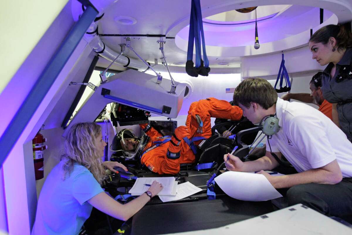 Boeing personnel talk with NASA Astronaut Randy Bresnik, center, inside a mock-up the Boeing CST-100 capsule during a flight suit evaluation at Boeing Houston Product Support Center, 13100 Space Center Boulevard, Monday, July 22, 2013, in Houston. ( Melissa Phillip / Houston Chronicle )