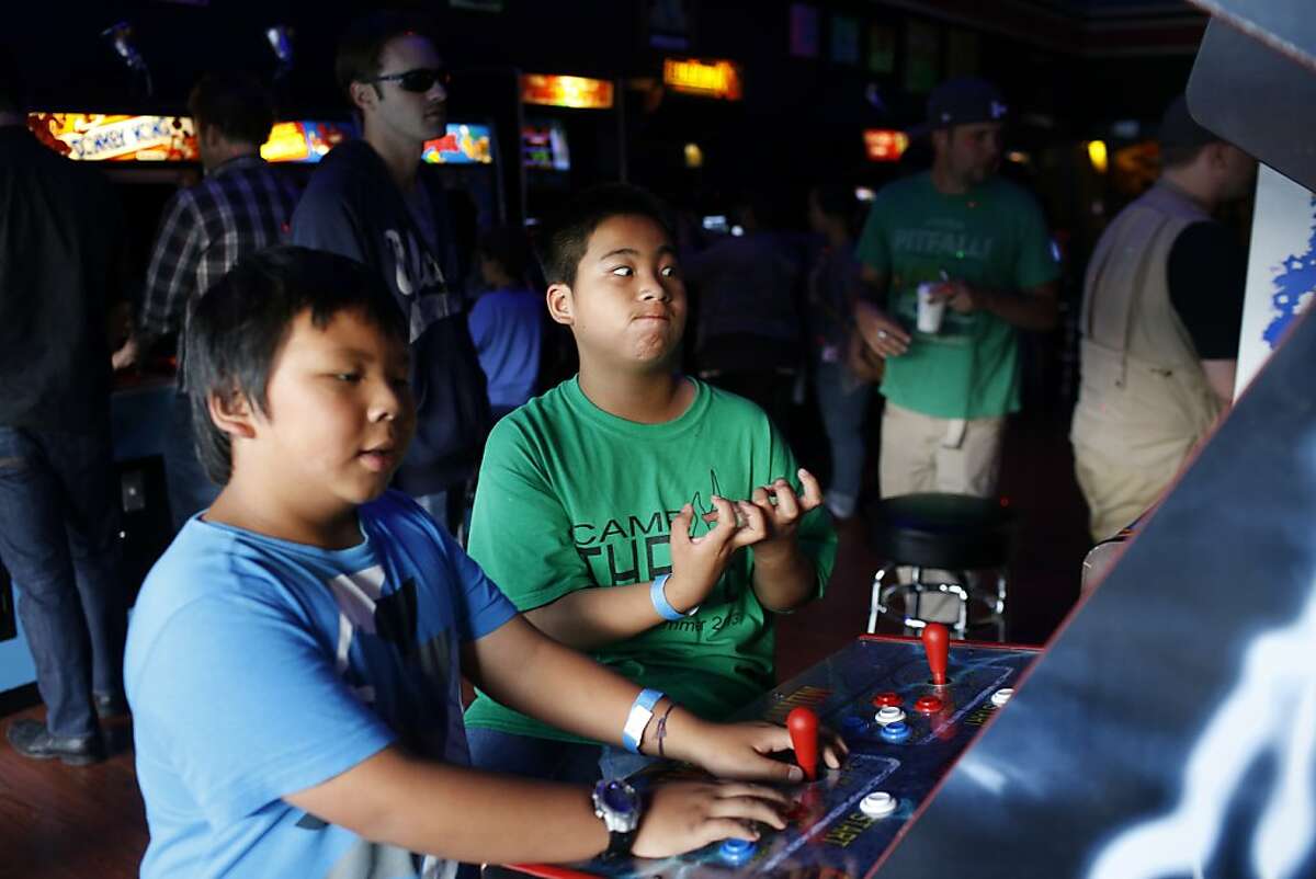Andrew Saephan, right, reacts to losing Mortal Kombat II while Joshua Saephan, left, continues to play at the High Score arcade in Alameda, California on July 12, 2013.