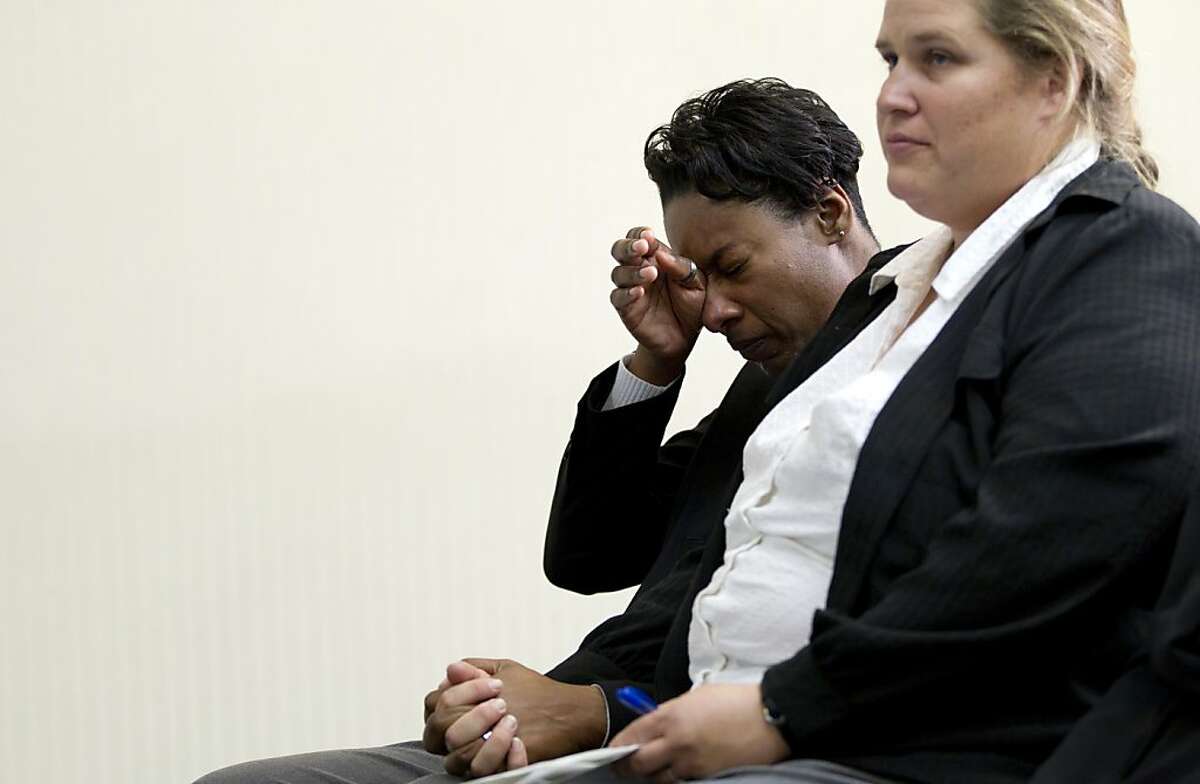 Tracey Cooper-Harris, who served in the Army for 12 years, left, wipes her eyes as she sits with her spouse Maggie Cooper-Harris after speaking at a news conference at the National Press Club in Washington, Wednesday, Feb. 1, 2012. Tracey Cooper-Harris is suing the federal government because she and her wife are being denied military benefits granted to heterosexual couples.
