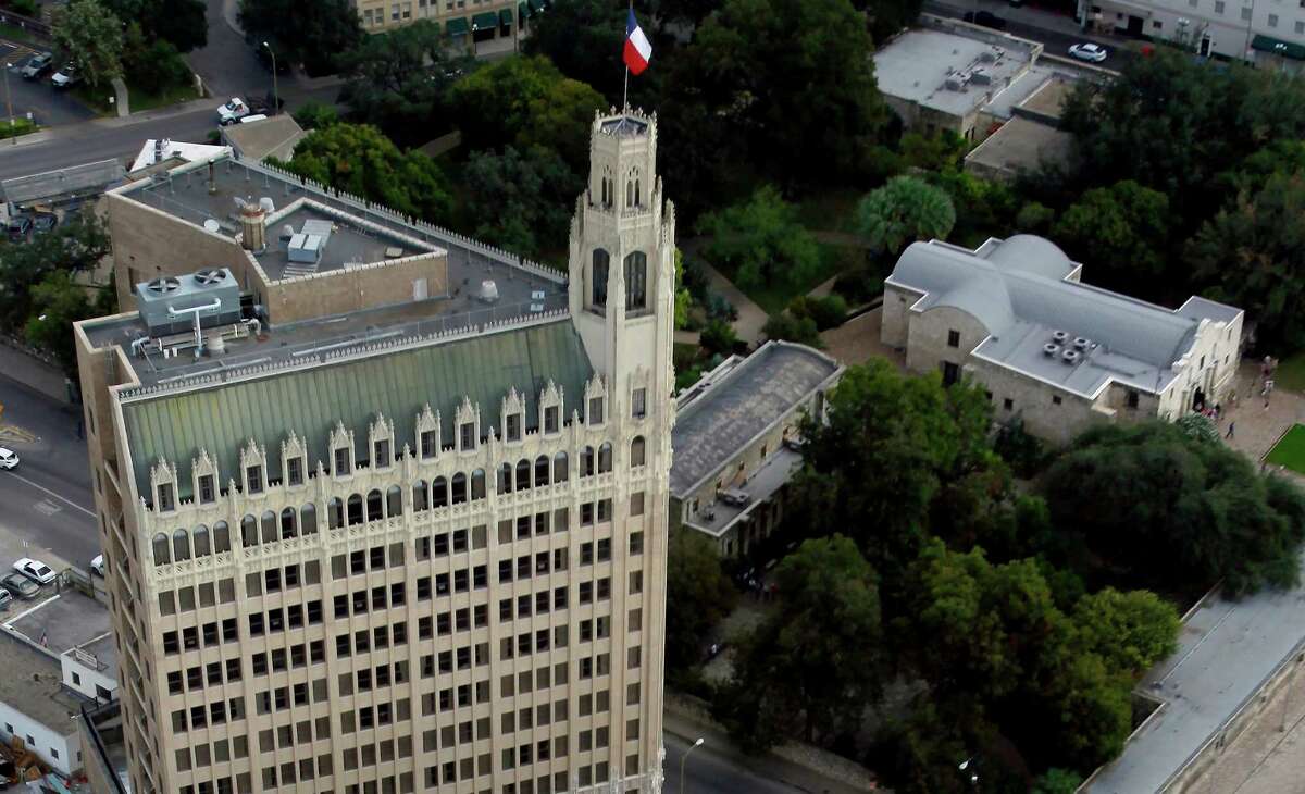 The Emily Morgan hotel stands next to the federal building while the Alamo can be seen surrounded by trees in the image. The Crocket Hotel and the Menger Hotel are seen at the very top of the image.