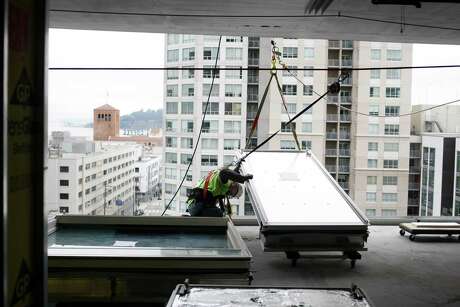 Gerardo Gonzalez works to install an aluminum panel during construction of the One Rincon Hill Phase Two project in San Francisco in 2013.