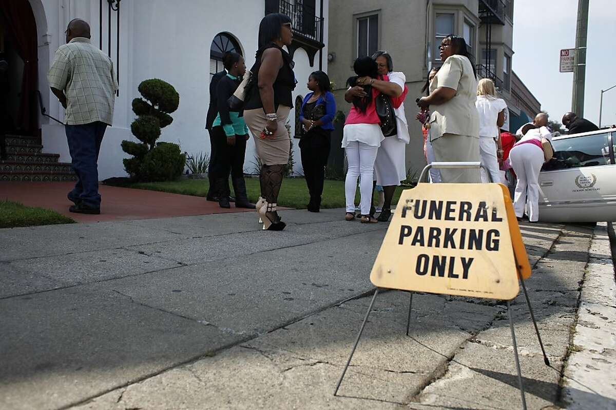 Family and friends comfort each other as they arrive for the funeral of Alaysha Carradine, Tuesday July 30, 2013, at the McNary-Williams-Jackson Mortuary in Oakland, Calif. Alaysha, 8, was shot and killed when a gunman opened fire through the door of a friend's house.