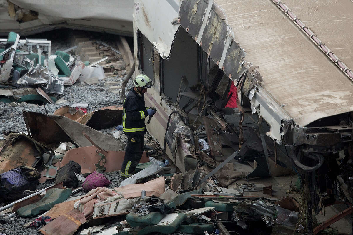 A firefighter works at the scene of a train crash that killed at least 77 people on July 25, 2013 at Angrois near Santiago de Compostela, Spain. The crash occurred on Wednesday at 8.40pm as the train approached the north-western Spanish city of Santiago de Compostela, with 247 passengers on board. At least 77 people have died and a further 131 have been reported injured. The crash occurred on the eve of Santiago de Compostela's main religious festival.