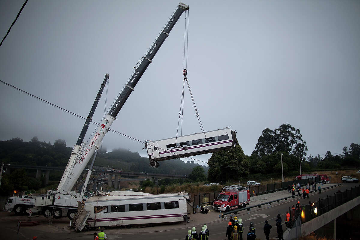 A carriage is lifted at the scene of a train crash on July 25, 2013 at Angrois near Santiago de Compostela, Spain. The crash occurred on Wednesday at 8.40pm as the train approached the north-western Spanish city of Santiago de Compostela, with 247 passengers on board. At least 77 people have died and a further 131 have been reported injured. The crash occurred on the eve of Santiago de Compostela's main religious festival, which has been cancelled by the City's officials.
