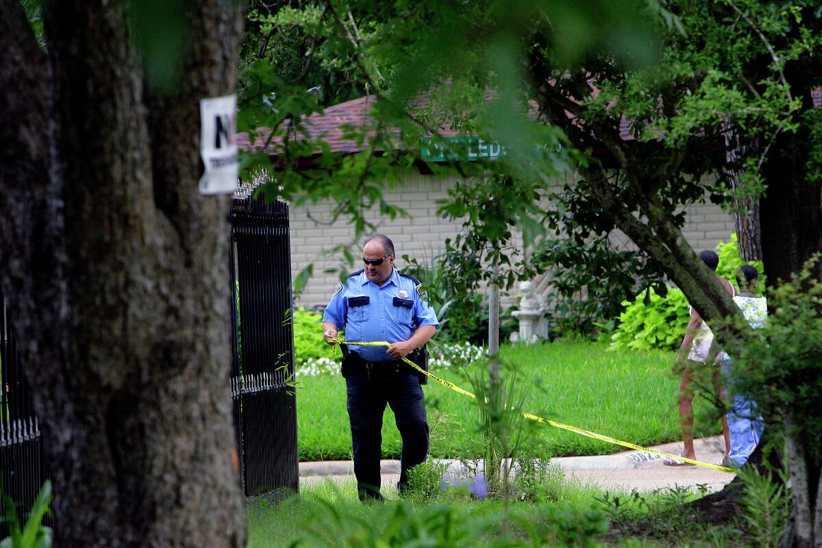 An officer tapes off a home on Friday in north Houston where four men told police they were locked in and not allowed to leave.