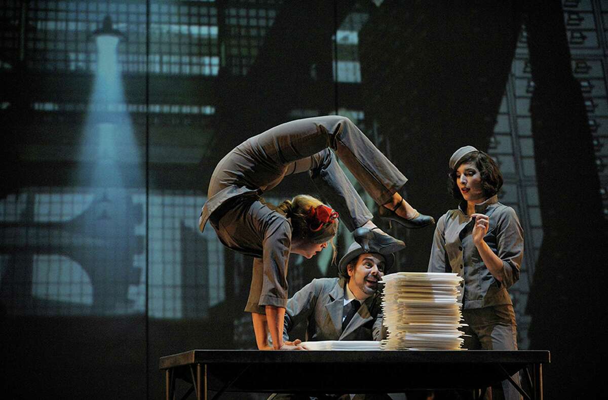 One man?s imagination transforms piles of papers, looming towers, and giant gears into a vibrant, romantic, and lavish cityscape. Lauren Herley, Ashley Carr, Myriam Deraiche perform. (Courtesy Cirque Eloize)