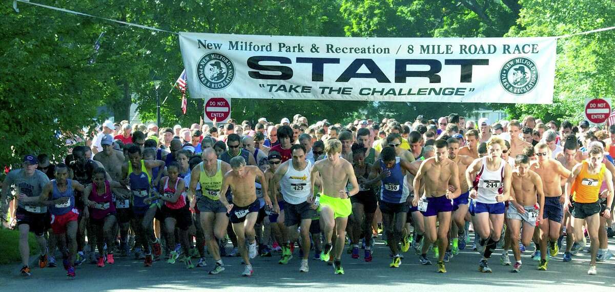 The field of nearly 600 runners and walkers responds to the starter's gun just after 9 a.m. on Saturday to kick off the 46th annual New Milford 8-mile and 11th annual Village Fair Days 5K road races. Side by side to the left are eventual 8-mile champions Mengistu Nebsi (7) and Aziza Aliyu (422) of Ethiopia. Among those directly under the banner are former New Milford resident George Adams (406), who finished 14th, Mike Nahom (429) of New Milford, who finished 10th, fifth-place finisher Jake Feinstein of Newtown, 11th-place Ryan Clarke (10) of New Milford and upcoming New Milford High senior Zach Guptill (244), who claimed 23rd place.