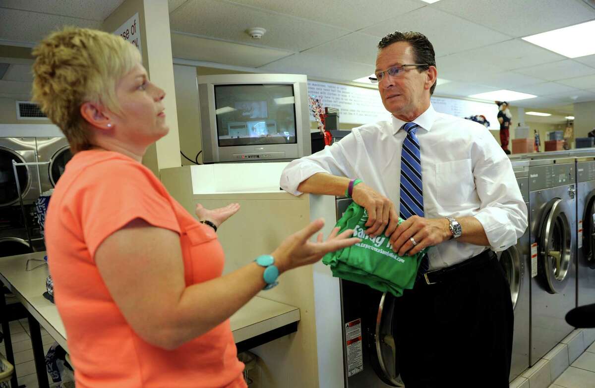 Sharon Doherty, owner of P.J.'s Laundramat in Sandy Hook, talks with Governor Dannel P. Malloy during his walking tour of the Sandy Hook business district Wednesday, July 31, 2013.