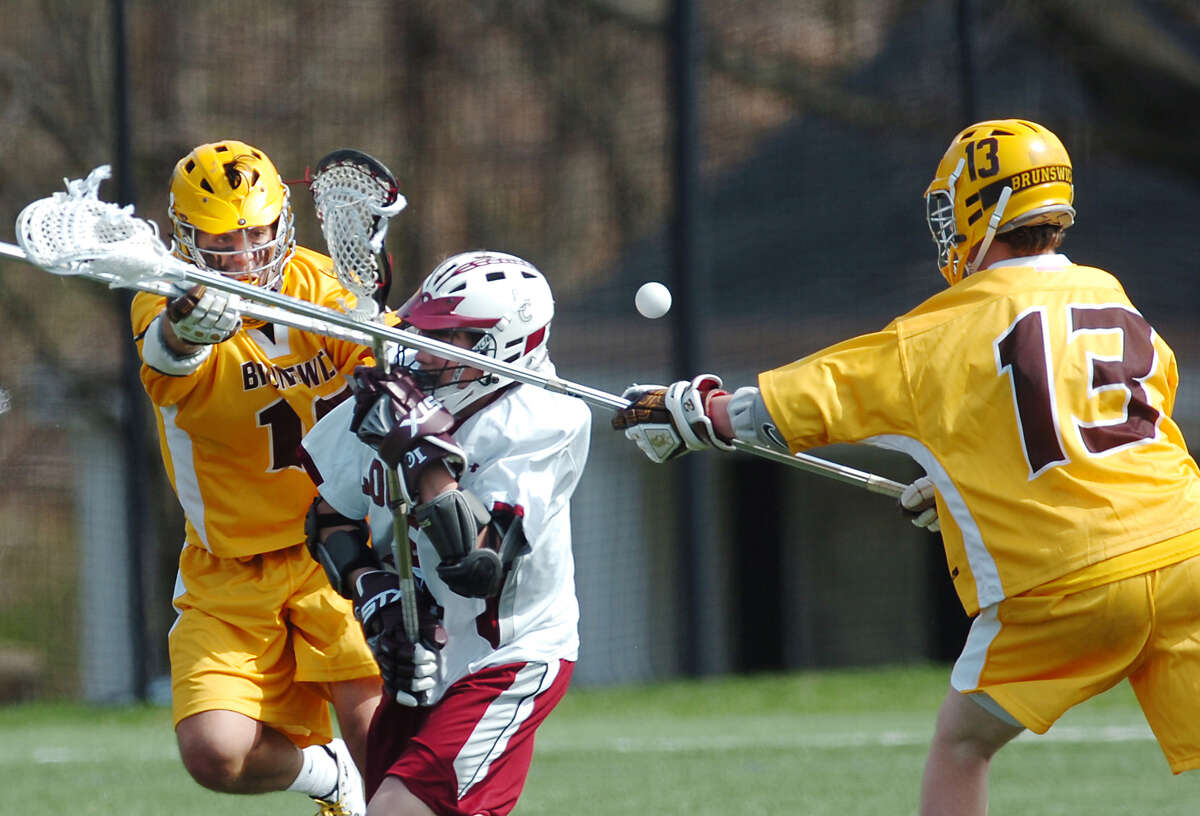 Jimmy Craft, # 10, left and David Beter, # 13, right, both Brunswick defenders dismantle Loomis Chaffee's Edward Black, # 5, center, during the Brunswick vs. Loomis Chaffee lacrosse game, Saturday, April 3rd, 2010, at Brunswick School.