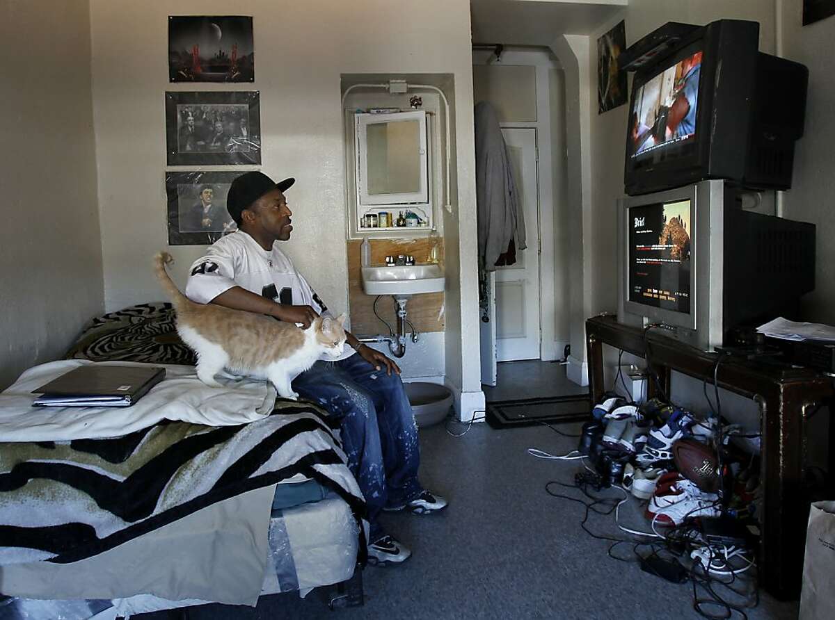 Vaughn Davis and his new cat watch television on his cable set at the Hartland Hotel. Ten years ago San Francisco officials decided that supportive housing for the homeless was the only solution. Although many formerly homeless are now housed, few have had the training, schooling or support to actually get off the streets during the day.
