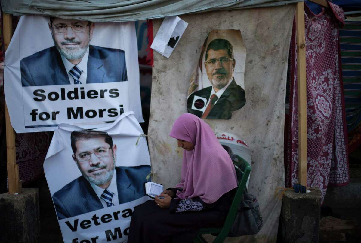 A supporter of Mohammed Morsi reads the Quran on Thursday outside a mosque, where protesters have camped and hold daily rallies in Cairo, Egypt.