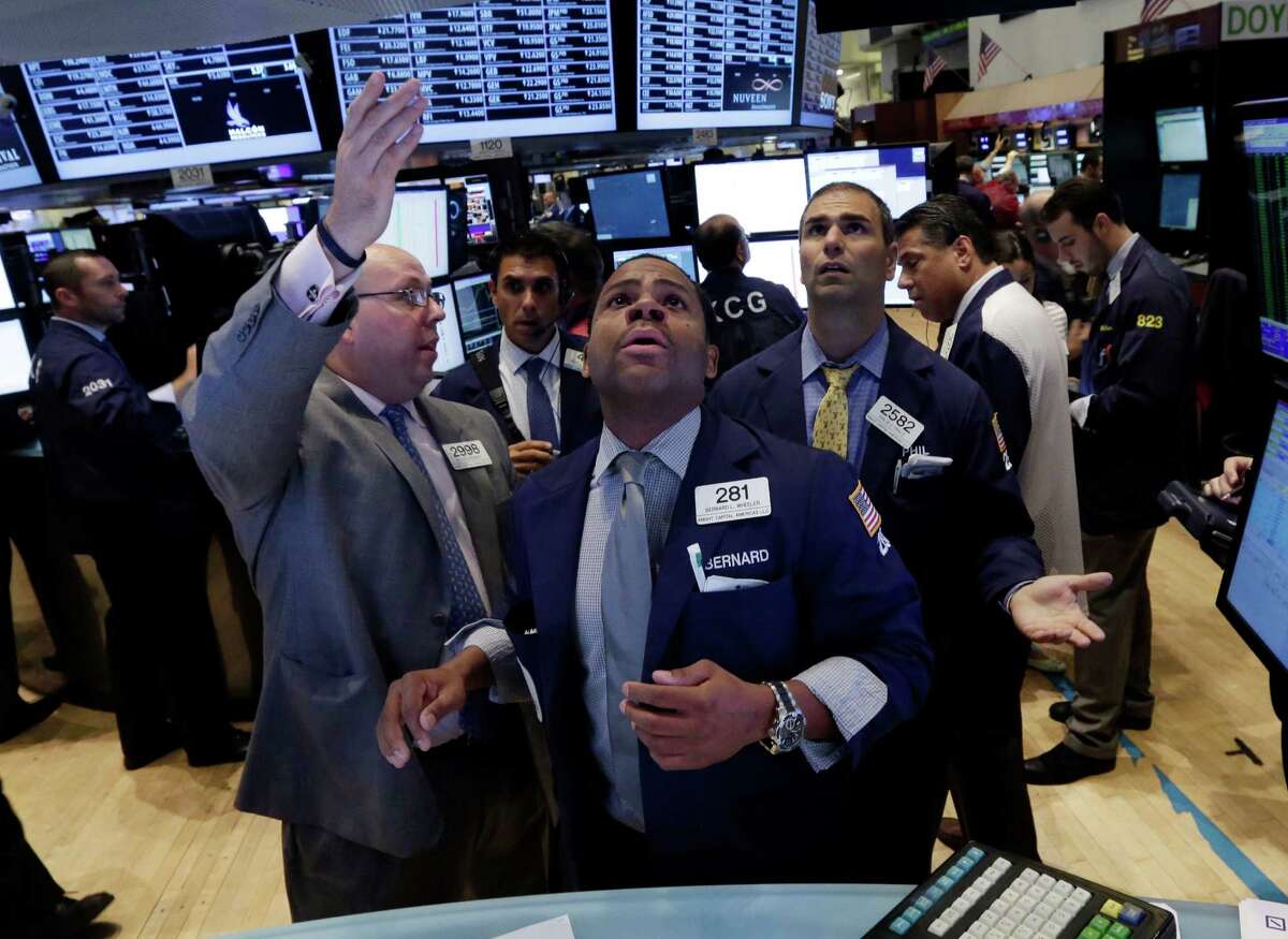 In this Wednesday, July 31, 2013, photo, from left, specialists Peter Kennedy, Bernard Wheeler, and Philip Finale, confer on the floor of the New York Stock Exchange. Global markets rose Thursday Aug. 1, 2013 after the U.S. Federal Reserve gave no indication it was preparing to wind down a massive bond-buying program that has propelled investors into stocks. (AP Photo/Richard Drew)