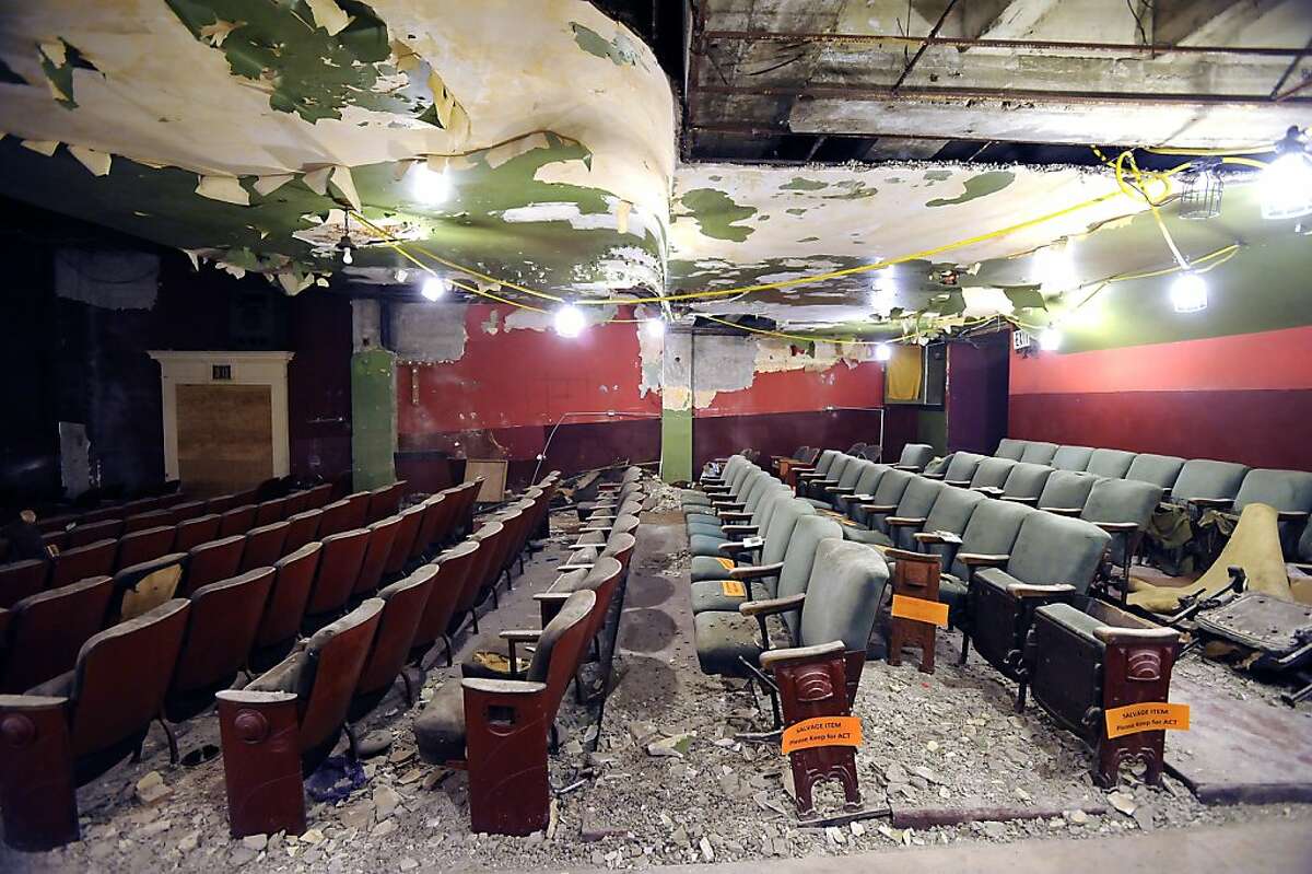Vintage seats, some marked for salvage, sit under a ceiling of peeling paint and piles of rubble at The Strand theater in San Francisco, CA Friday July 12th, 2013. The Strand movie theater on the skid row stretch of Mid-Market Street, has been bought by ACT and will be converted to a stage for dramatic performance.