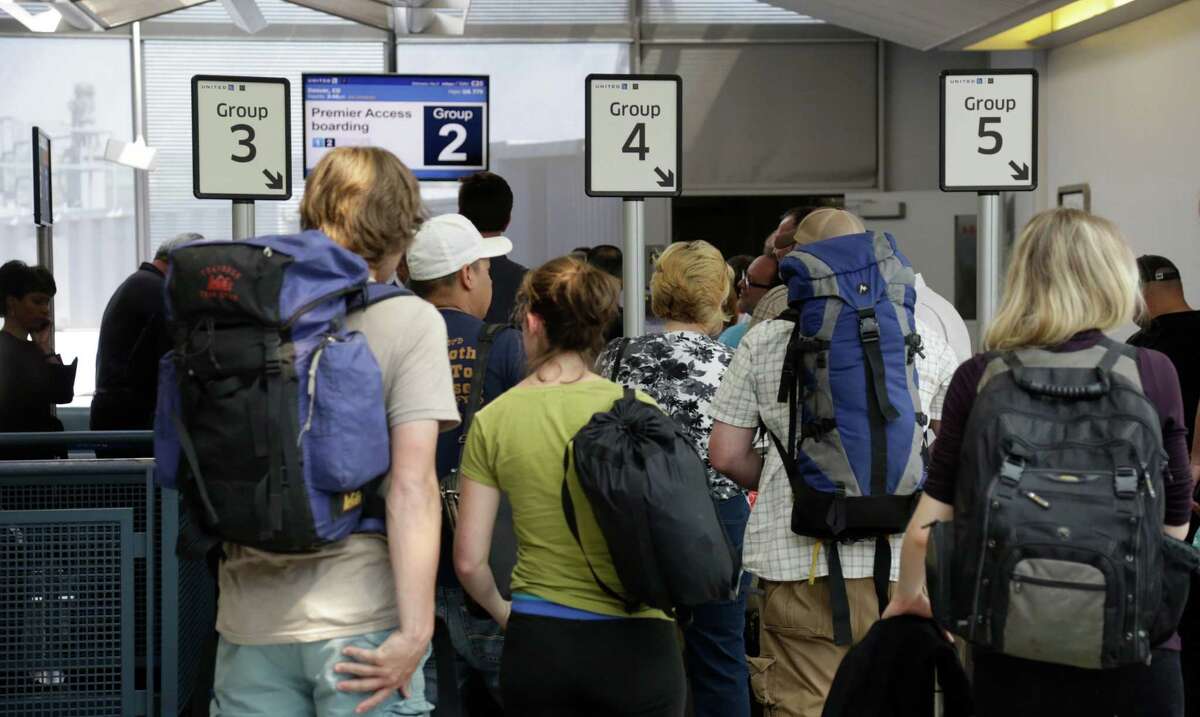 United passengers in Chicago wait to board a flight in separate numbered lanes.