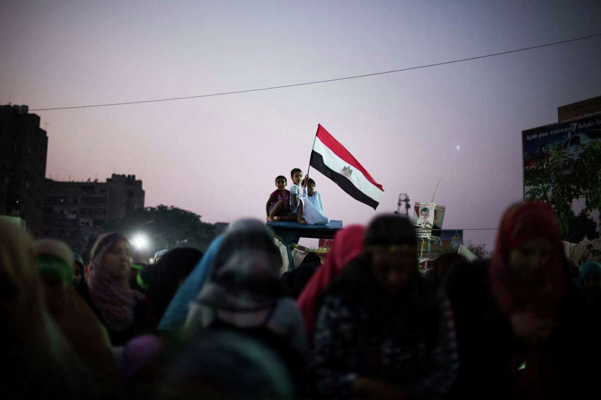Egyptian children wave a national flag Friday as supporters of Egypt's ousted President Mohammed Morsi pray in Nasr City, a part of Cairo.