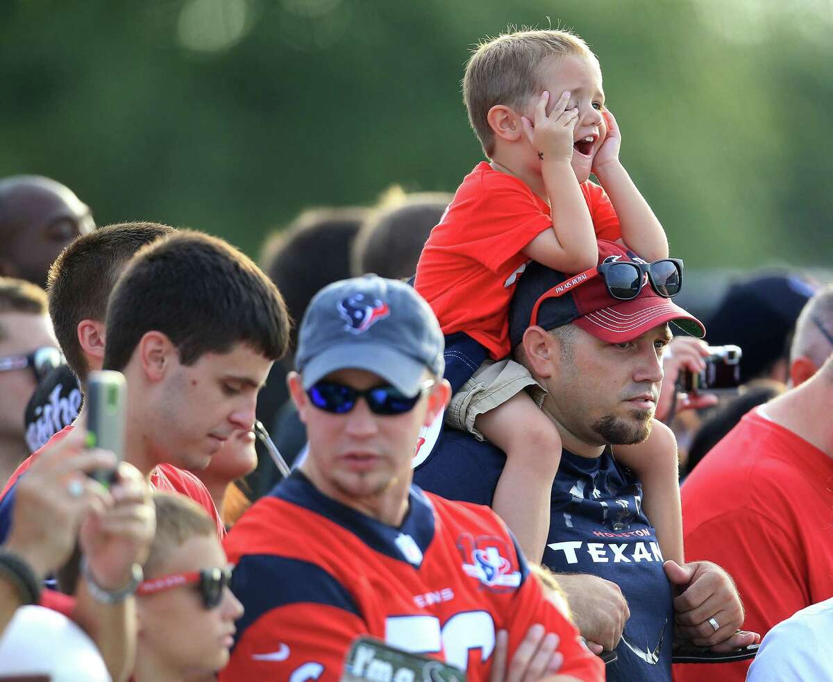 Connor Wakefield, 3, of Texas City, sits on the shoulder of his dad, Ricky,as they watch players during Houston Texans training camp at Methodist Training Center at Reliant Park, Friday, Aug. 2, 2013, in Houston. ( Karen Warren / Houston Chronicle )