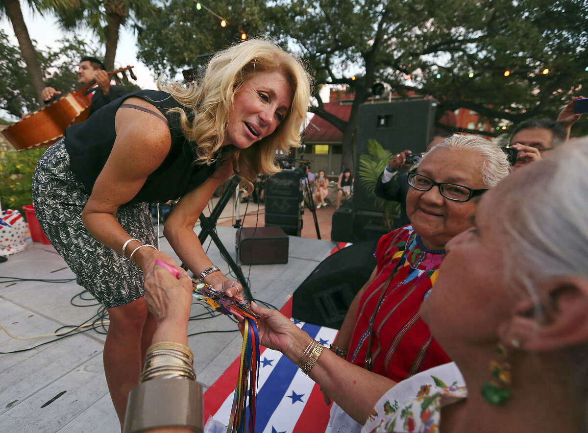 State Sen. Wendy Davis (left) accepts a fused-glass heart from Gloria Uribe (right) and Enedina Casarez Vasquez (center) during the inaugural Bexar County Democratic Party Family Reunion at Maverick Plaza in La Villita.