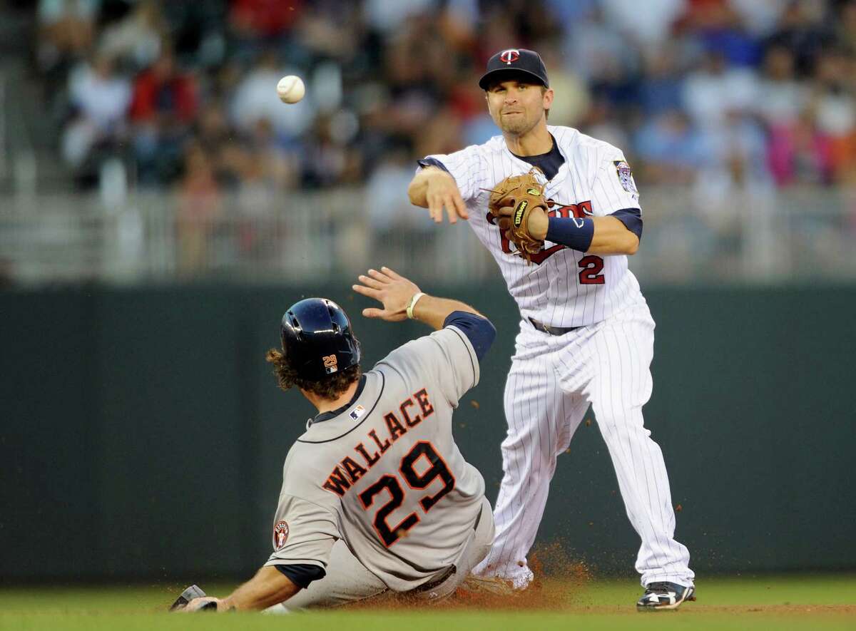 Twins second baseman Brian Dozier turns a double play in the fourth inning by first making a sliding Brett Wallace, left, the lead out. Nine innings later, Dozier turned hero at the plate with a game-ending RBI single.