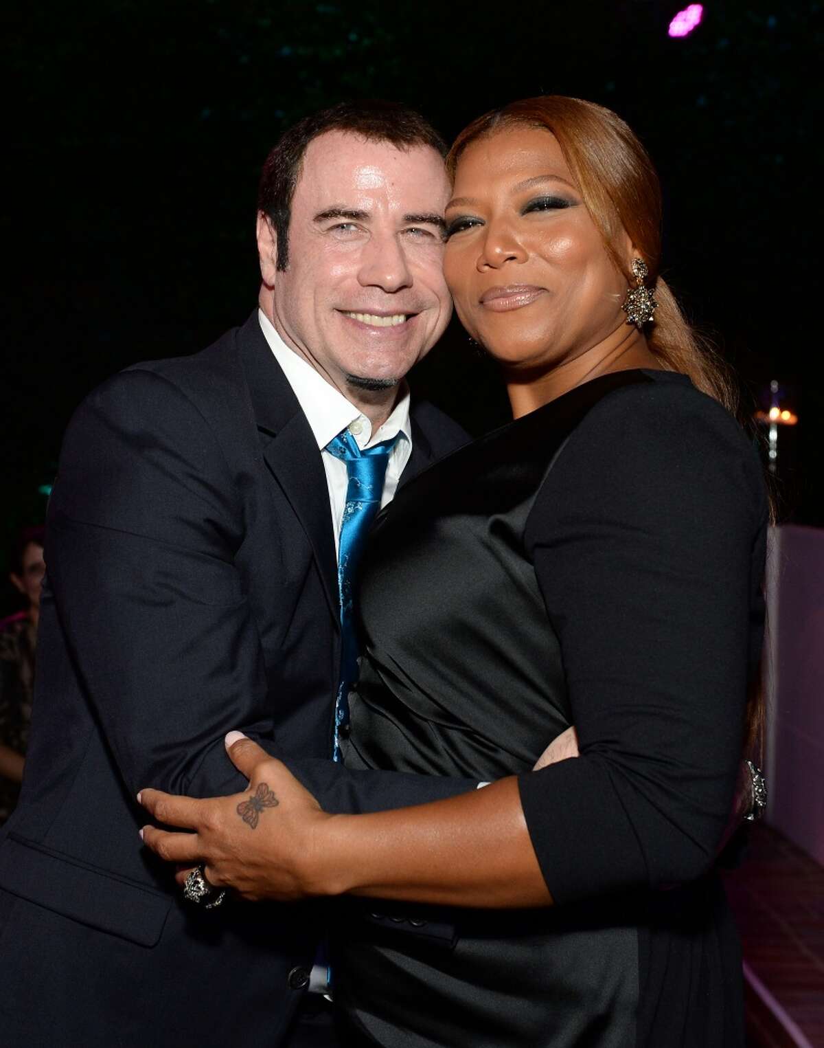 Actor John Travolta (L) and singer Queen Latifah attend the 87th birthday celebration of Tony Bennett and fundraiser for Exploring the Arts, the charity organization founded by Mr. Bennett and wife Susan Benedetto, hosted by Ted Sarandos & Nicole Avant Sarandos among celebrity friends and family on August 3, 2013 in Beverly Hills, California.