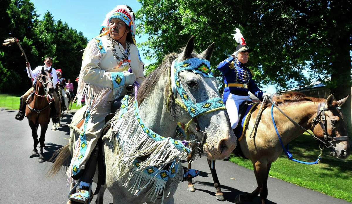 Gus High Eagle, left, and Maj. Gordon Johnson lead the way as the riders of the Dakota Nation make a ceremonial ride through the gates of the "fort" with the Second Company Governer's Horse Guard in Newtown, Conn., as part of the Unity Ride, Monday, Aug. 5, 2013.