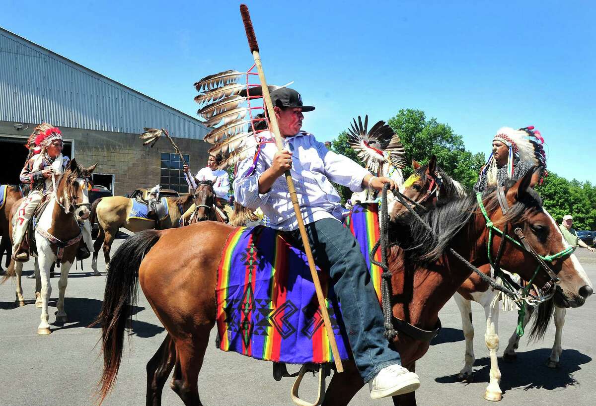 Tyrone Chaske rides his horse, Sally, as the riders of the Dakota Nation make a ceremonial ride through the gates of the "fort" with the Second Company Governor's Horse Guard in Newtown, Conn., as part of the Unity Ride, Monday, Aug. 5, 2013.