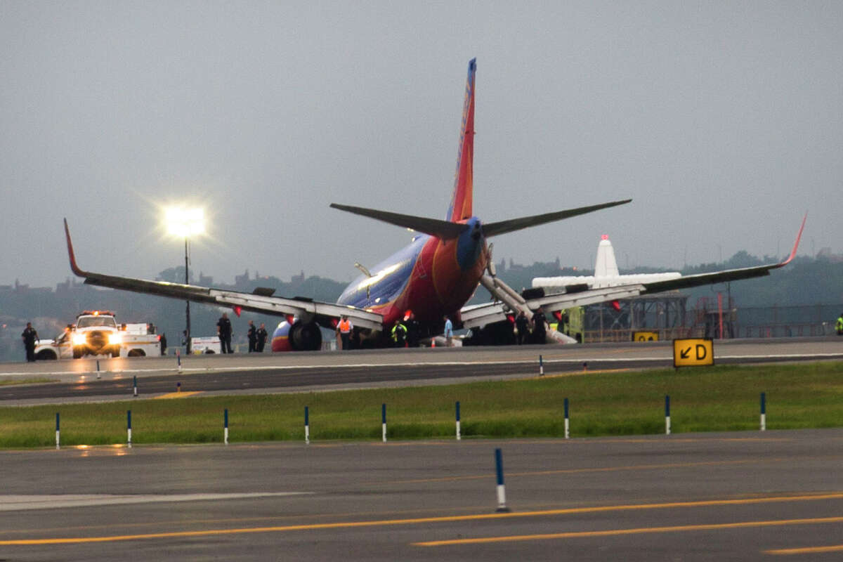 FILE - In this Monday, July 22, 2013, file photo, a Southwest airlines plane rests on the tarmac after what officials say was a nose gear collapse during a landing at LaGuardia Airport, in New York. The National Transportation Safety Board on Tuesday, Aug. 6, 2013 said that the captain of the plane took control from the first officer just 400 feet from the ground. Ten people were injured in the July 22 accident, which the NTSB is still investigating. (AP Photo/John Minchillo, File)