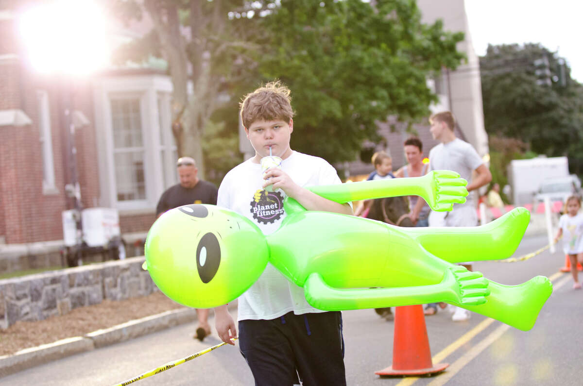 Ryan Sawyer, 12, of Greenwich, carries a giant green alien he won down Hamilton Avenue during opening night of the annual St. Roch Feast at St. Roch Church in Greenwich on Wednesday, Aug. 7, 2013 and ran through Saturday Aug. 10, 2013.