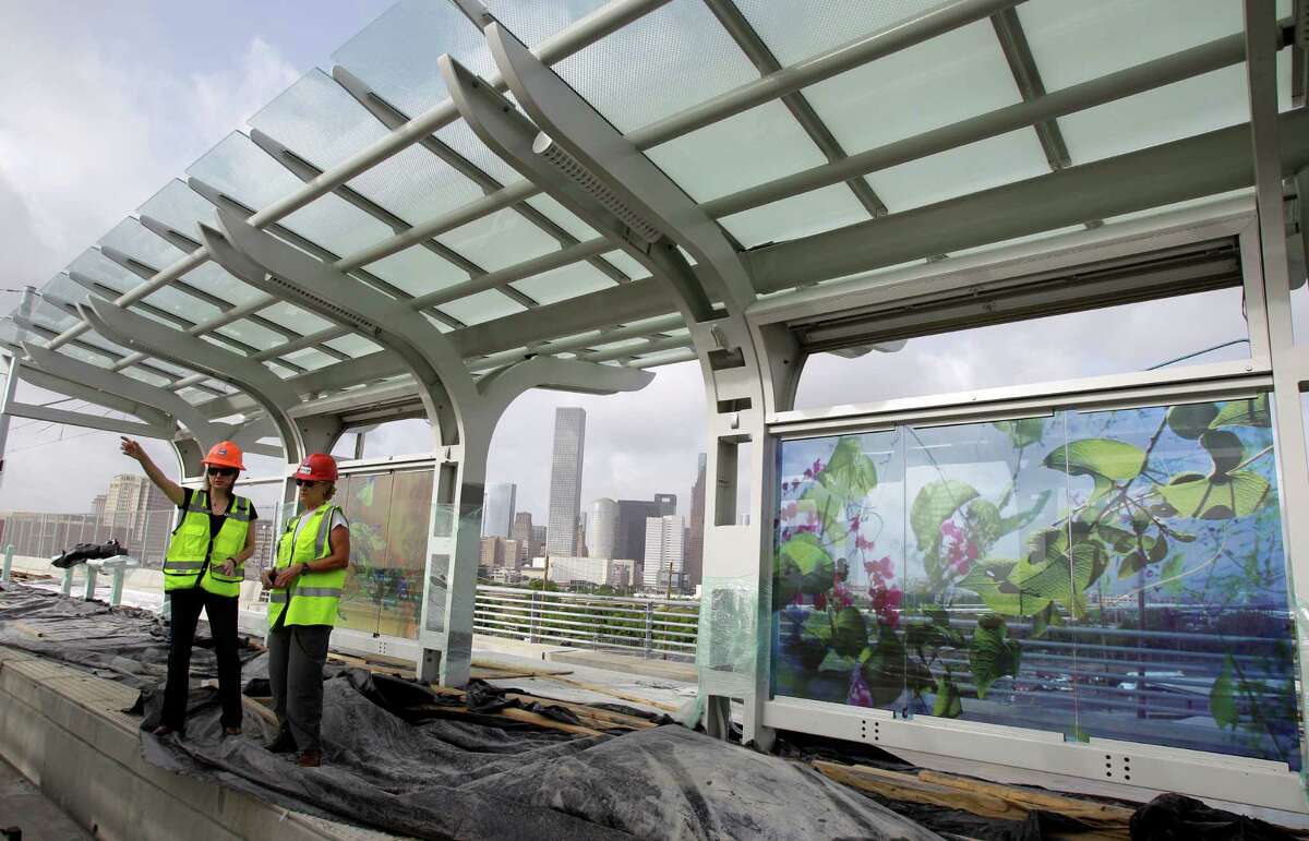 Sara Kellner, left, arts in transit manager at Houston Rapid Transit, and Margaret O'Brien-Molina, right, Metro media relations specialist, talk about the display of artwork by Dixie Friend Gay at the Burnett Station on Metro's Northline light rail Wednesday, Aug. 7, 2013, in Houston. ( Melissa Phillip / Houston Chronicle )