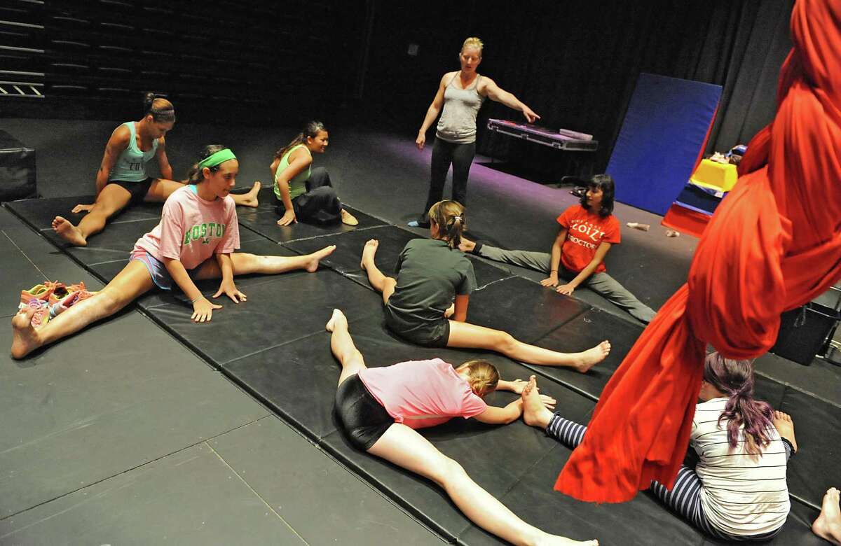 Circus artist and instructor Shannon Maguire of St. Paul, Minn., center, and Myriam Deraiche of Quebec, right, teach students the proper techniques for stretching to be a contortionist during Cirque Eloize circus school Monday, Aug, 5, 2013, at the GE Theatre at Proctors in Schenectady, N.Y. (Lori Van Buren / Times Union)